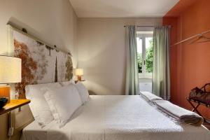 a bedroom with a bed with white sheets and a window at La Meirana in Gavi