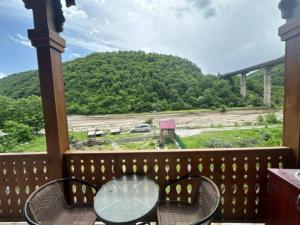 un tavolo e sedie su un balcone con vista su un ponte di otherside a Ananuri