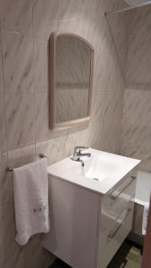 a bathroom with a white sink and a mirror at Apartamento con Encanto y Vistas al Mar en Getaria in Getaria