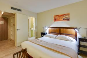 A bed or beds in a room at Kyriad Perpignan Sud