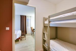 A bed or beds in a room at Kyriad Perpignan Sud