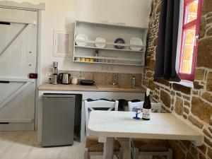 a kitchen with a table with a bottle of wine at Rodakas Rooms-Adigoni in LivadhokhÃ³rion