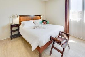 A bed or beds in a room at Kyriad Perpignan Sud