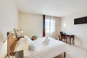 A bed or beds in a room at Kyriad Perpignan Sud