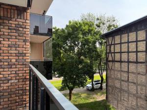 a brick building with a window next to a tree at Prywatny Parking przy Starówce Apartament Logan by Rentoom in Toruń