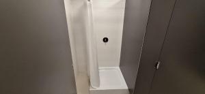 a shower stall with a white shower curtain in a bathroom at Jacht AMBER in Gdańsk