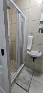 un baño con ducha y lavabo en Grace Villas 35, en East London