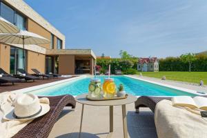 ブルトニグラにあるVilla Sanpadeo by Rent Istriaの家の隣にテーブルと椅子付きのスイミングプール