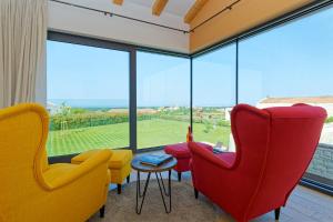a room with colorful chairs and a large window at Villa Sanpadeo by Rent Istria in Brtonigla