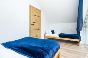 a bedroom with two beds and a blue blanket at Apartamenty SeaLife in Sarbinowo +59 photos