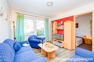 a living room with a blue couch and a table at Ferienhaus Schweriner See in Retgendorf