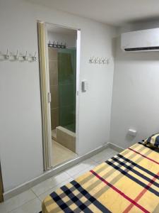 a bedroom with a mirror and a bed and a shower at Habitación cerca a la playa 104 in Cartagena de Indias