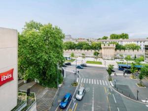 una strada cittadina con auto parcheggiate in un parcheggio di ibis Avignon Centre Gare ad Avignone