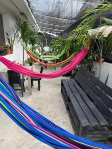 a group of hammocks in a room with a bench at Habitación cerca a la playa 104 in Cartagena de Indias
