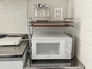 a microwave oven sitting on a shelf in a kitchen at Ire Stay in Seoul