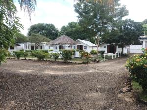 a house with a gravel driveway in front of it at Hôtel-bungalows La Pirogue in Sambava