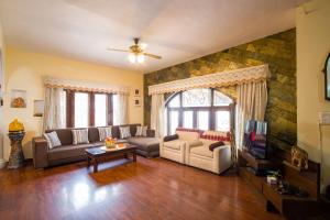 ein Wohnzimmer mit Sofa und Fernseher in der Unterkunft Heaven on Hills by The StayCationer in Bhīm Tāl