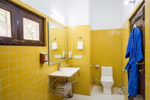 ein gelb gefliestes Bad mit einem Waschbecken und einem WC in der Unterkunft Heaven on Hills by The StayCationer in Bhīm Tāl + 14 Fotos