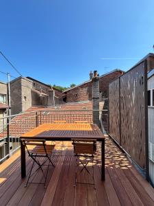 a wooden table and chair on a wooden deck at Pueblo Bonito Epinal avec Terrasse in Épinal