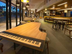 eine Klavierbank in einem Restaurant mit Tischen und Stühlen in der Unterkunft ibis Styles Taubate in Taubaté