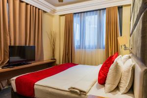 a hotel room with a bed and a television at Coral Grand Beach & Spa in Hulhumale +22 photos