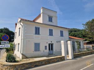 a white building on the side of a street at Duplex Apartment Valter Strunjan in Strunjan