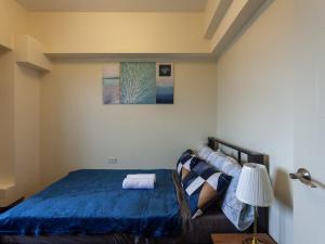ein Schlafzimmer mit einem Bett mit blauer Bettdecke in der Unterkunft Family-Ready Skyline Retreat near BGC with Free Parking in Manila + 32 Fotos