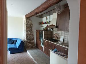 a kitchen with a blue couch in a room at La casa tra i monti in Ponna Superiore