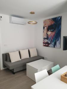 un soggiorno con un divano e un quadro sul muro di Bayunca 6 a Madrid