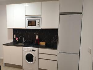 una cucina con lavatrice e microonde di Bayunca 6 a Madrid