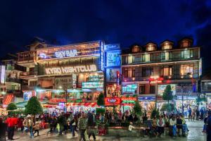 库尔卢Hotel Vijayant - By The Mount Heaven的晚上，一群人在建筑物前行走