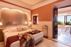 A bed or beds in a room at Alhambra Palace Hotel