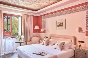 a bedroom with a large white bed and a window at Alhambra Palace Hotel in Granada
