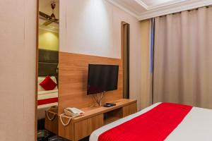 a hotel room with a bed and a television at Coral Grand Beach & Spa in Hulhumale