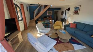 a living room with a blue couch and a table at Le nid d'hirondelle in Sainneville-sur-Seine