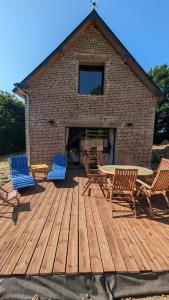 a wooden deck with chairs and a table and a fireplace at Le nid d'hirondelle in Sainneville-sur-Seine +9 photos