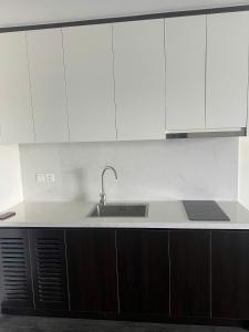 - une cuisine avec un évier et des placards blancs dans l'établissement Homestay Sapphire Hạ Long, à Hạ Long