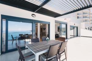 a dining room with a table and chairs on a patio at Orange Villa - 7 Bedrooms - 5 Star Location - Views - Pool in Dobra Voda