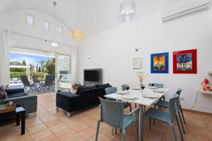 a dining room and living room with a table and chairs at Villa Zina by Ezoria Villas in Meneou