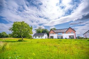 a house on a green field with a tree at Spacious Countryside Barn House in Little Bridgeford