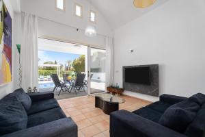 a living room with a couch and a television at Villa Zina by Ezoria Villas in Meneou