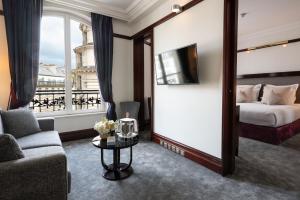 a hotel room with a bed and a couch and a table at Hôtel Pont Royal Paris in Paris