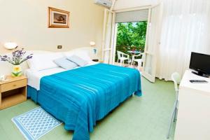 リド・ディ・サヴィオにあるHotel Beverlyのベッドルーム1室(青い毛布付きのベッド1台付)