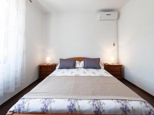 a bedroom with a large bed with two lamps at Guest House Rooms Rose in Molunat
