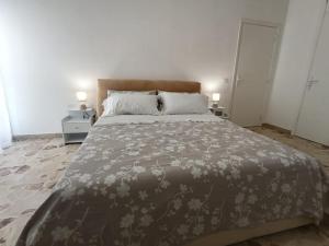 a bedroom with a large bed with a brown blanket at Marinella House in Siracusa