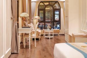 a bedroom with a bed and a table and chairs at Delina Castle Coffee & Hotel in Hanoi