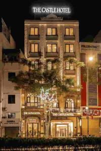 a building with a tree in front of it at Delina Castle Coffee & Hotel in Hanoi