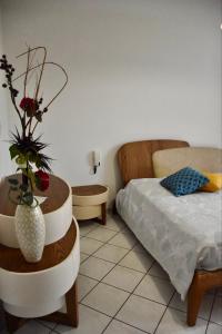 a bedroom with a bed and a vase with flowers in it at La casa di Paride in Porto Cesareo