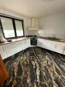a kitchen with white cabinets and a large rug at House Garden near Paris Roissy Calm zone in Les Pavillons-sous-Bois