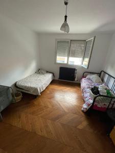 a bedroom with two beds and a wooden floor at House Garden near Paris Roissy Calm zone in Les Pavillons-sous-Bois